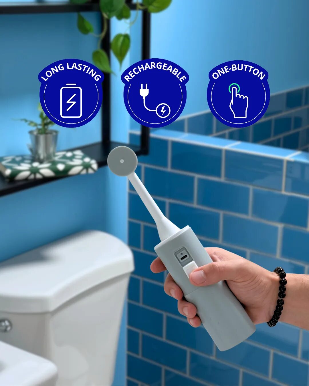 Hand holding a gray BumBum portable bidet: long-lasting, rechargeable, one-button